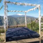 A photo of the view of Mount Etna through a Balinese bed at Vista Alcantara in Sicily