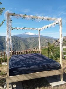 A photo of the view of Mount Etna through a Balinese bed at Vista Alcantara in Sicily